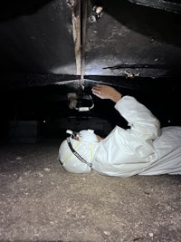 a person in a white suit crawling on the ground